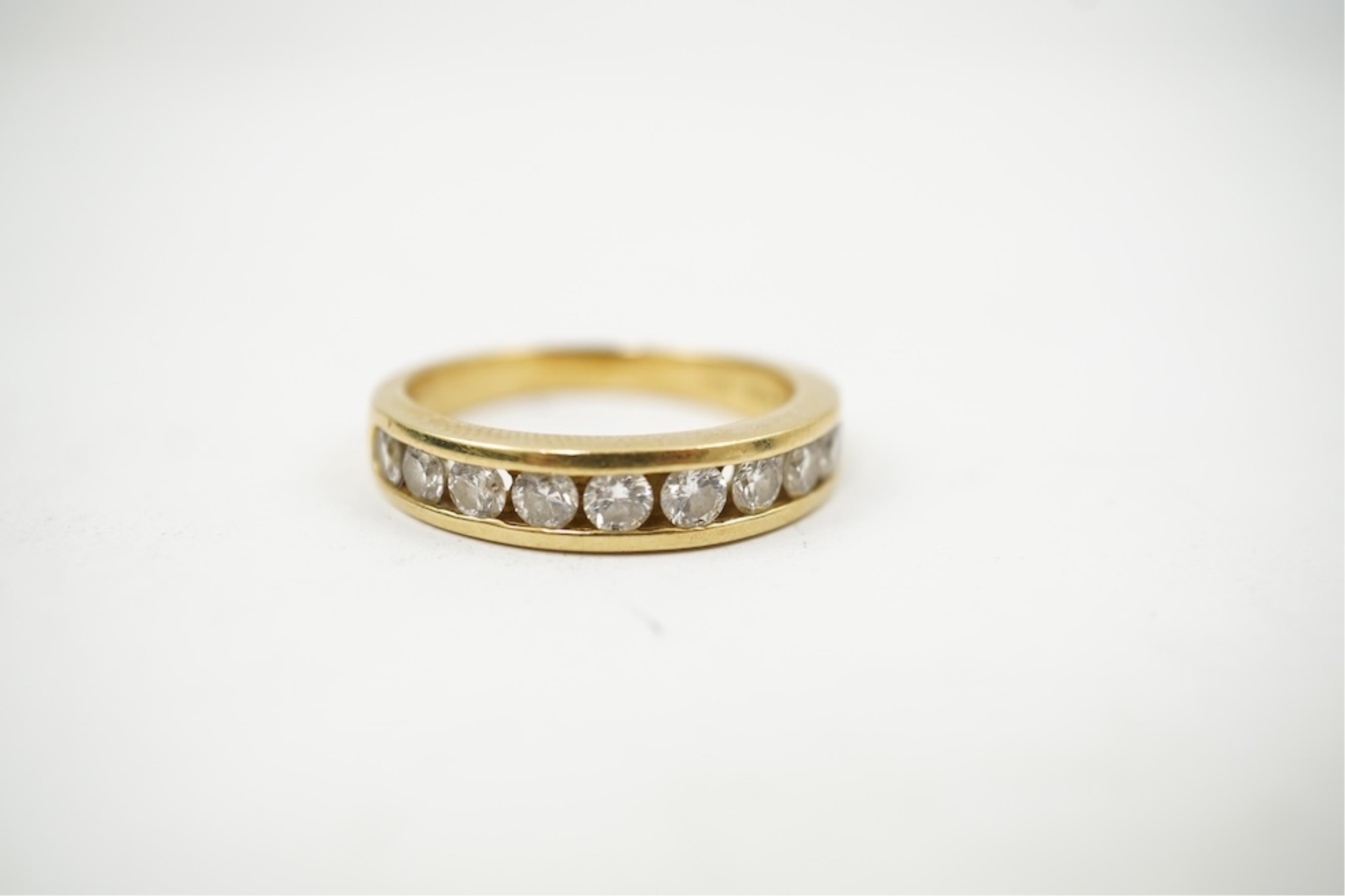 A modern 18ct gold and channel set graduated ten stone diamond set half eternity ring, size Q, gross weight 5.4 grams.